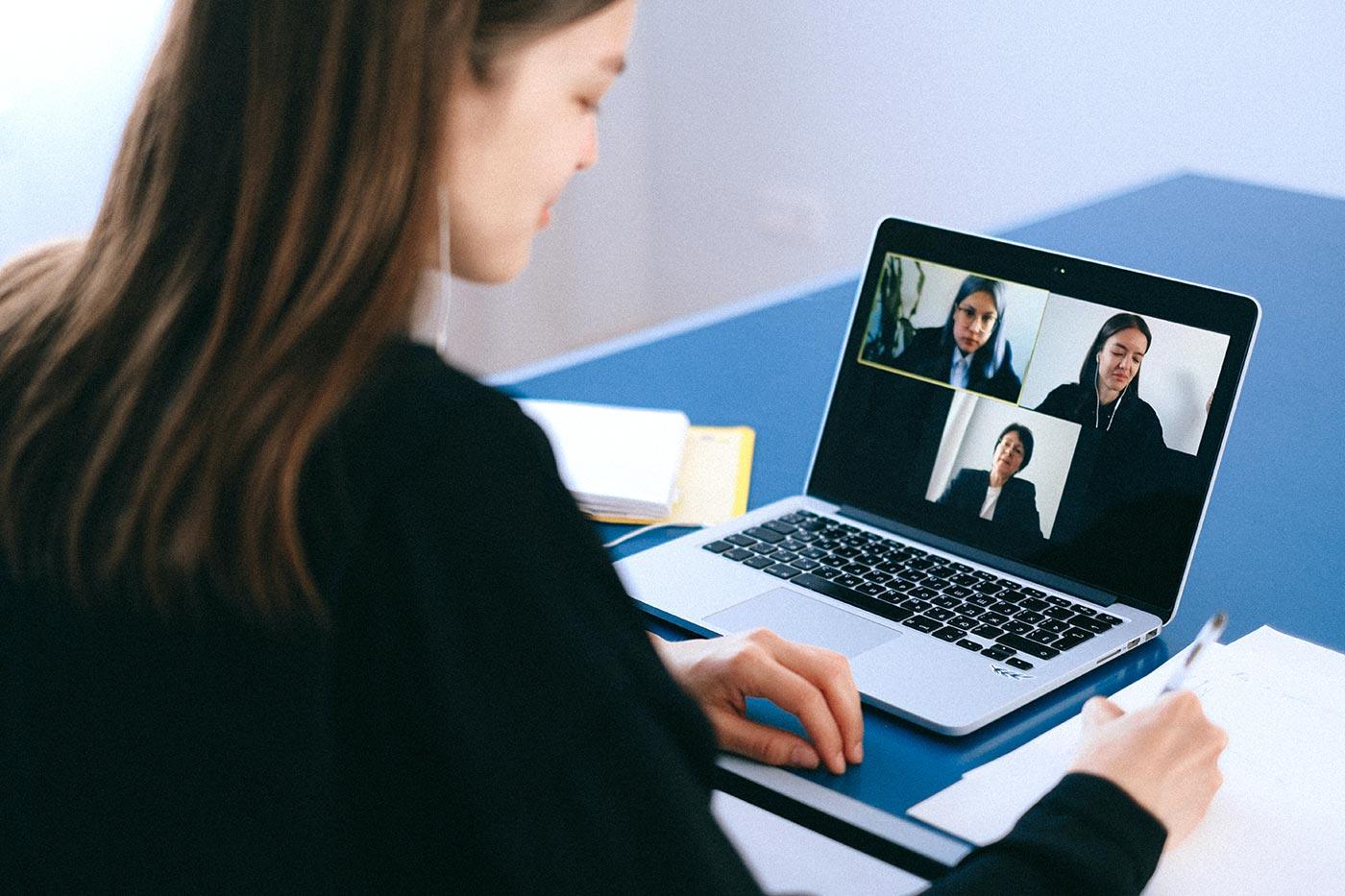 woman works on laptop for meeting over Zoom call