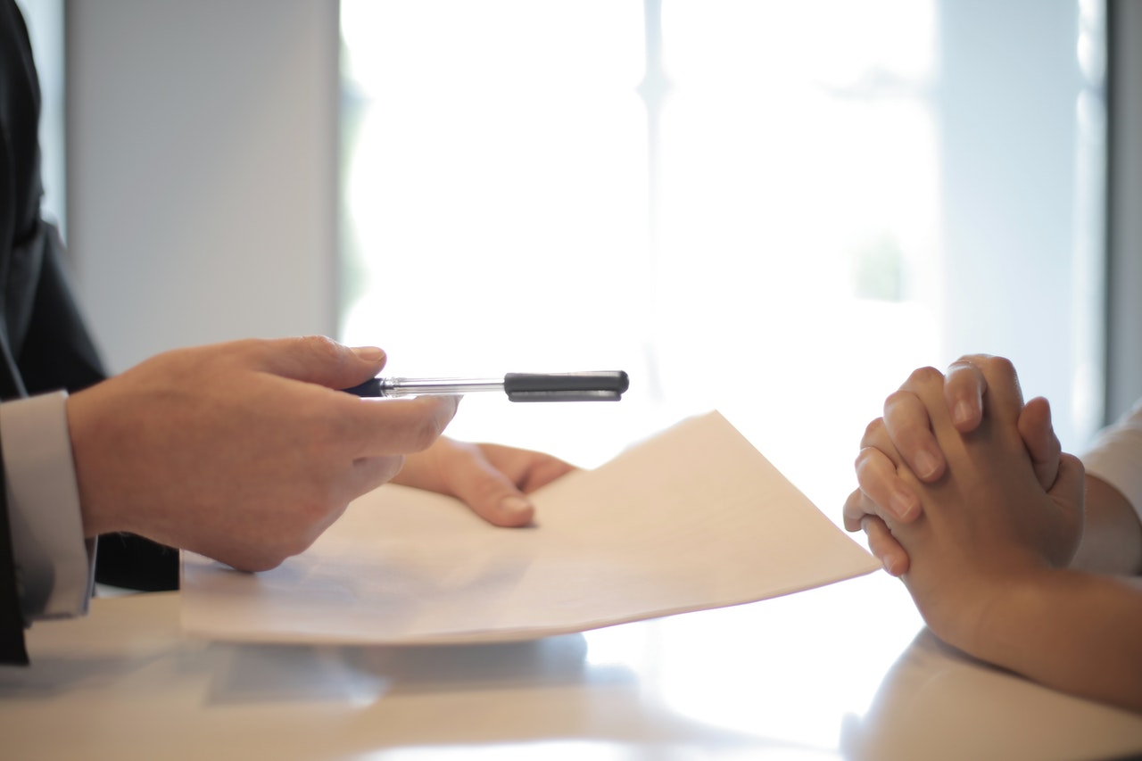 businessman giving contract to a woman to sign