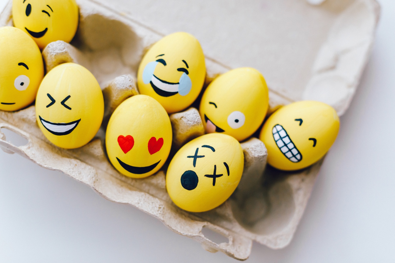 eggs painted as emojis in an egg carton